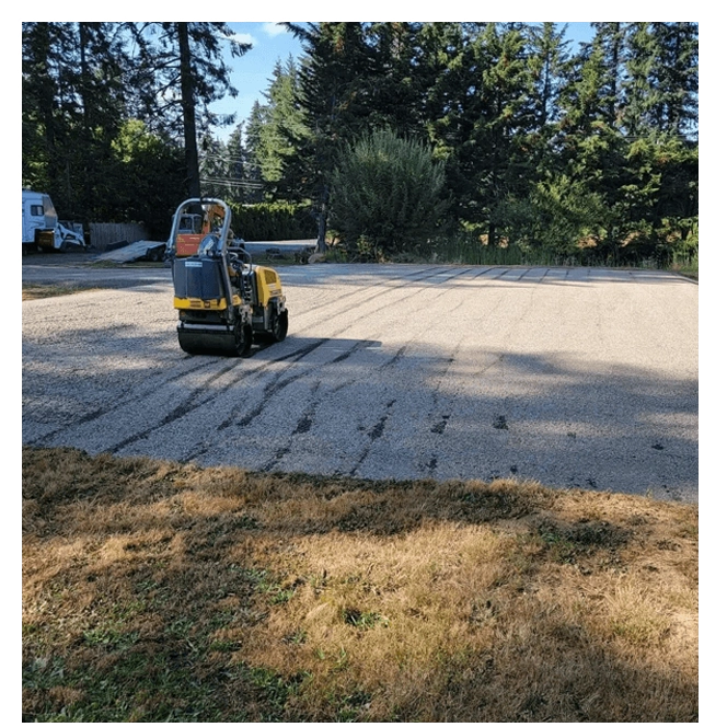 A small yellow and black truck parked in the middle of a driveway.