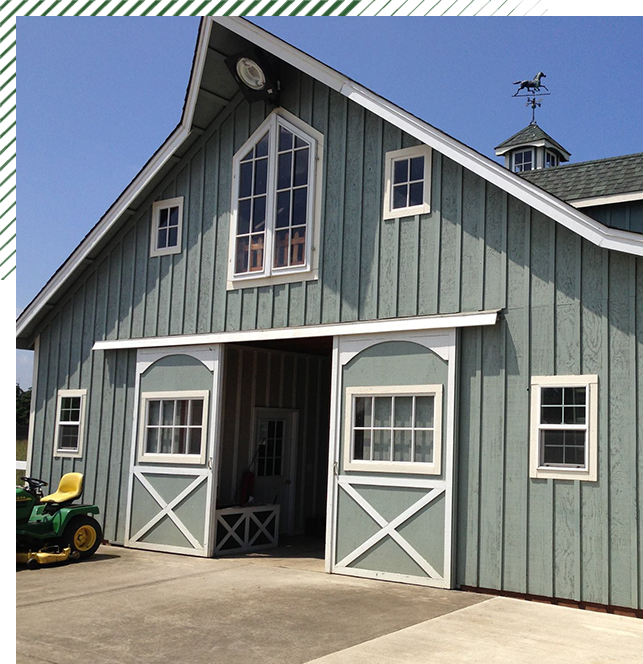 A barn with two large windows and a green tractor.